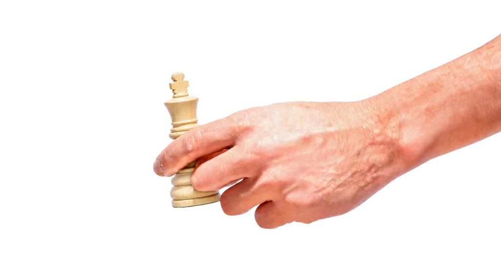 Una mano sostiene una pieza blanca de ajedrez